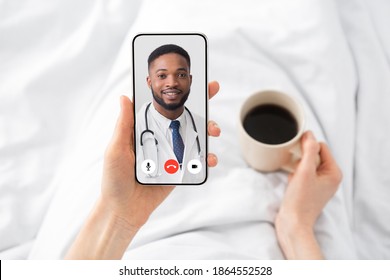 Woman Having Video Call With Doctor Lying In Bed At Home. Online Medical Consultation Concept. Virtual Clinic Helpline And Mobile Healthcare App. Physician Consulting Patient Distantly. Cropped
