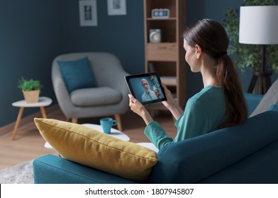 Woman having a video call with her doctor using a digital tablet, telemedicine concept