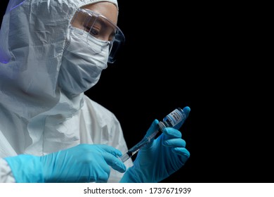 Woman in hazmat suit with vaccine and syringe injection for prevention, immunization and treatment from corona virus infection. - Shutterstock ID 1737671939