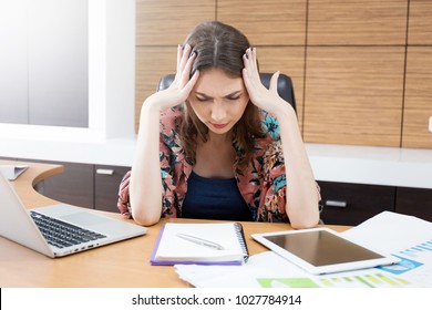 Woman headache after hard work in her office.