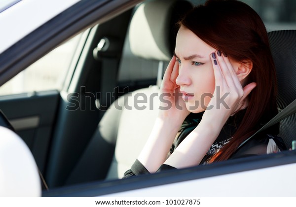 Woman with headache in a\
car
