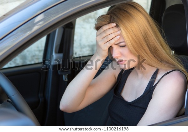 Woman with headache in a\
car