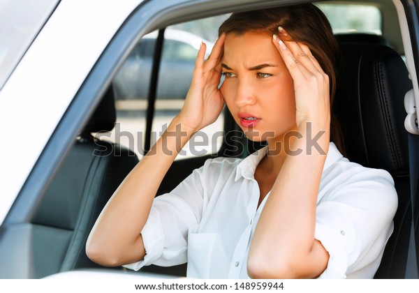 Woman with headache in a car\
