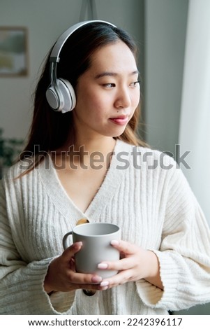 Woman in headphones with cup of coffee