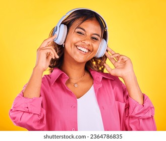 Woman, headphones and listen to music in portrait, happiness and entertainment on yellow background, Fun, audio streaming and radio with rave or techno in studio, student with wireless tech and smile - Shutterstock ID 2364786835