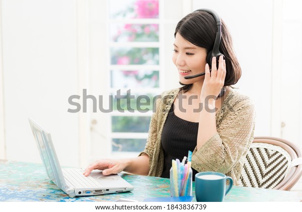 a\
woman with headphones sitting in front of a\
computer
