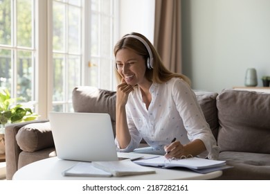 Woman In Headphones Studying From Home Using Video Call App, Sit At Table With Laptop, Makes Notes Improve English Knowledge With On-line Tutor. Remote Class, New Skills, Virtual Meeting Event