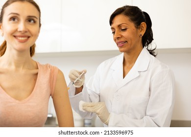 Woman Healthcare Worker Giving Injection To Patient At Doctors Office