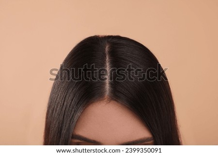 Woman with healthy hair on beige background, closeup