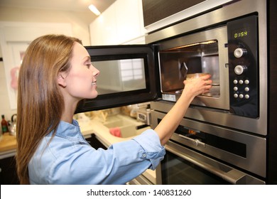 Woman Heating Dish In Microwave