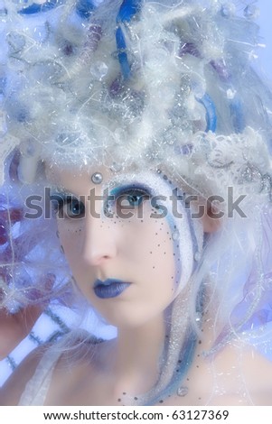 Woman with heavy stage makeup looking like a winter fairy.