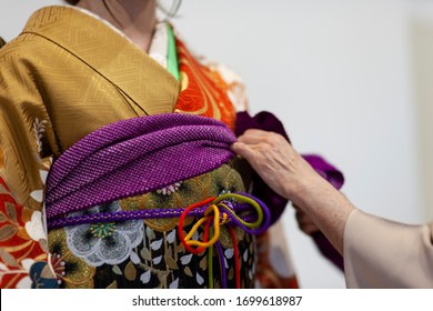 Femme aidant une fille à porter du kimono