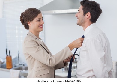 Woman Helping Her Husband To Tie His Tie Before Going To Work