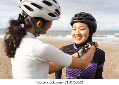 Woman Helping Her Muslim Friend To Fasten Her Bike Helmet