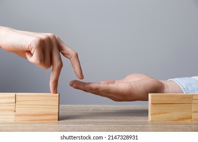 Woman Helping Her Partner To Cross Unfinished Bridge At Wooden Table, Closeup. Connection, Relationships And Deal Concept