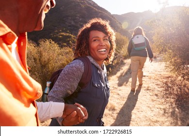 Woman Helping Man On Trail As Group Of Senior Friends Go Hiking In Countryside Together - Shutterstock ID 1722926815