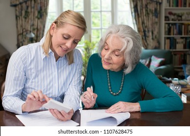 Woman Helping Senior Neighbor With Paperwork