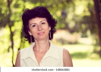 Woman in her 50s smiling outdoors portrait