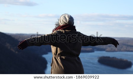 Woman with her arms stretched out looking of the beautiful view of the Susquehanna river from pinnacle overlook in holtwood Pennsylvania