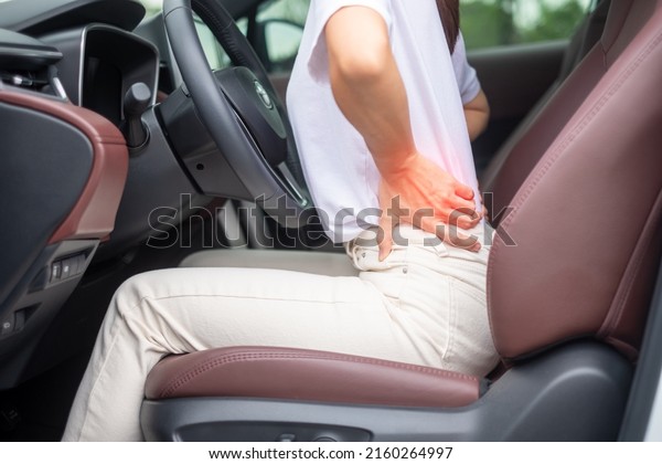 woman with her back sprain\
while driving car long time, back body ache due to Piriformis\
Syndrome, Low Back Pain and Spinal Compression. Ergonomic and\
medical concept