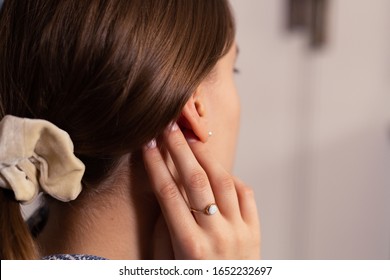 Woman With Her Blond Hair In Ponytail With Light Scrunchie. Close-up. Blurry Background.