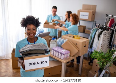 Woman And Her Colleague Working In Homeless Shelter. Cheerful Food Drive Manager. Happy Diverse Group Of Volunteers At Food Bank. Happy Woman Volunteers At A Food Bank 