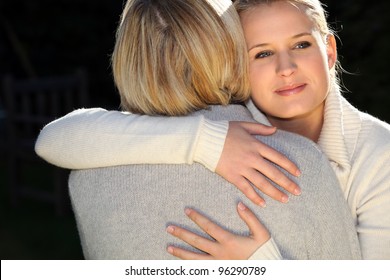 A woman and her daughter hugging.