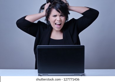 Woman At Her Desk Working On A Laptop Computer Pulling Out Her Hair