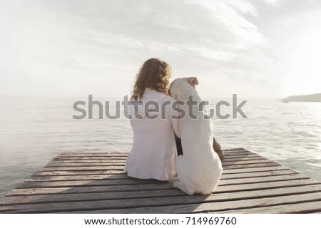woman and  her dog admire together the scenery 