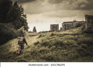 woman and her dog is heading for abandoned buildings. post apocalypse. stone walls