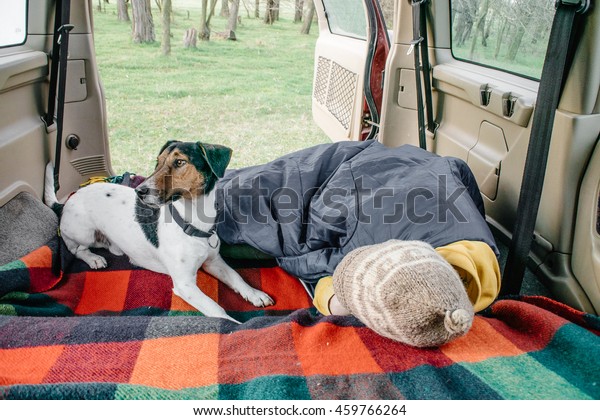 Woman and her dog\
resting in car interior