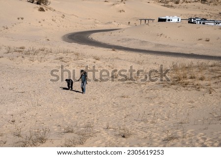 A woman and her dog walking in tha Texas desert
