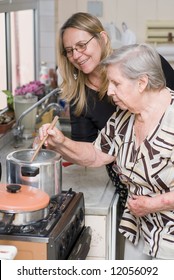 Woman And Her Elderly Mother Cooking A Meal Together