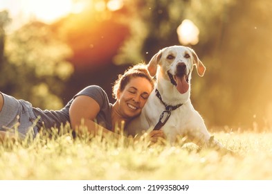 A Woman and her friend dog on the Beautiful sunset background - Powered by Shutterstock