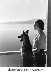 Woman and her German Shepherd overlooking a lake - Shutterstock ID 92506174