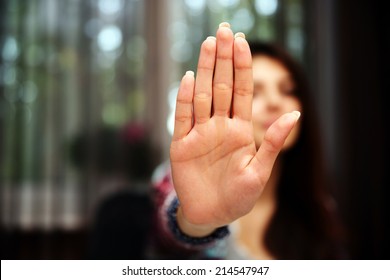 Woman with her hand extended signaling to stop (only her hand is in focus) - Shutterstock ID 214547947