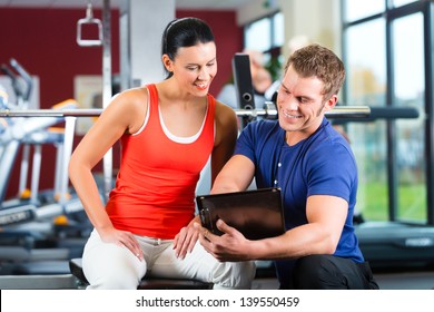 Woman With Her Personal Fitness Trainer In The Gym