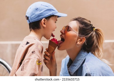 Woman with her son enjoying family time walking in the city together on a sunny day, eating ice cream. Happy family parent with little child boy kid enjoy outdoor lifestyle. Mum and sun lick gelato.