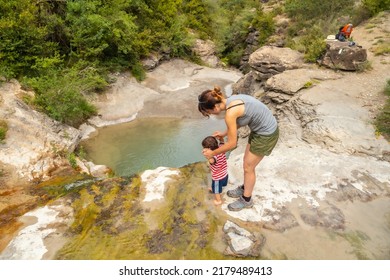 A Woman With Her Son In A River In Summer Cooling Off In The Pyrenees, Panticosa