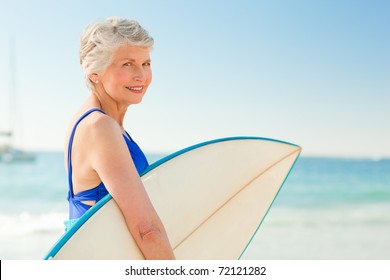 Woman with her surfboard at the beach - Powered by Shutterstock