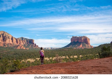 Woman Hicking In Red Reck County In Sedona Arizona With Clouds And Blue Skies