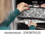 woman hides American dollars under a box in her underwear. stash cash dollars. High quality photo