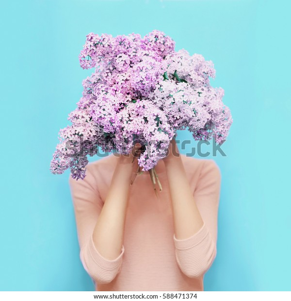 女人隐藏头花束紫丁香花在五颜六色的蓝色背景库存照片 立即编辑