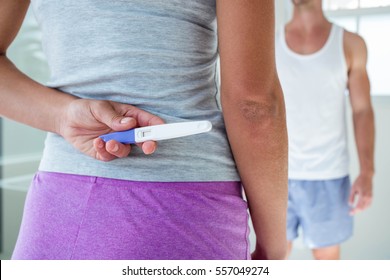 Woman Hiding Pregnancy Test Behind Her Back In Bathroom