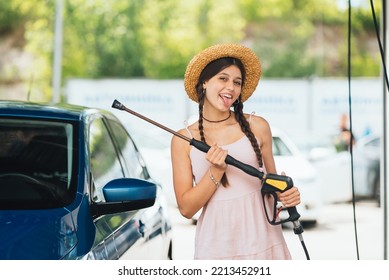 Woman With High Pressure Hose At Car Wash