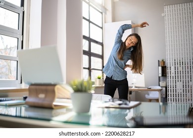 Woman In Hijab Standing And Stretching In Front Of Computer