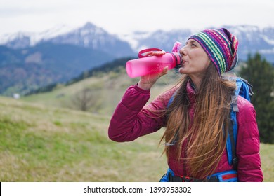 Woman Hiker With Backpack Driking From Reusable Water Plastic Bottle Outdoors In Nature