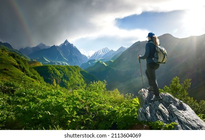 Woman Hiker with Backpack look view beautiful summer mountain landscape in the area of the Gudauri ski resort. Country Georgia.
				Beautiful inspirational landscape, trekking and activity. Travel sport 