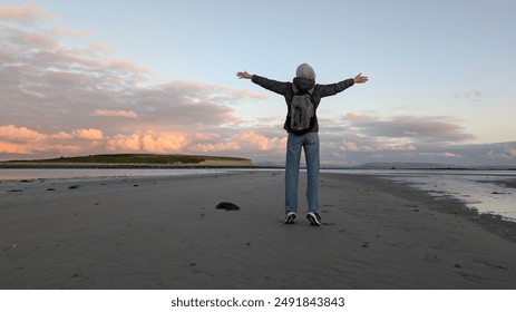 woman hiker backpacker enjoying coastal sunset scenery at sandy Silverstrand beach, Galway, Ireland, adventure and lifestyle concept, people in nature background - Powered by Shutterstock