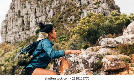 Woman Hiker Climbing Up On A Mountain. Young Female Hiking Over Extreme Terrain.